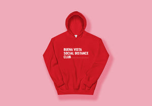 Red hoodie reads "Buena Vista Social Distance Club" in white all caps writing and ruler tick mark design