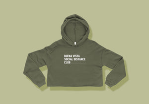Cropped army green hoodie reads "Buena Vista Social Distance Club" in all caps white lettering with ruler tick mark design
