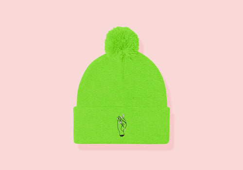 Neon green cuffed beanie with pom. Embroidered hand holding a dart in black and white